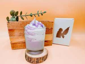 Cette image représente la bougie gourmande lilas et sa boîte blanche.