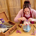 Composition d'un bouquet de fleurs en cire parfumée dans un arrosoir lors d'un atelier créatif à la Boutique Atelier Les Fées Mères à Charmes