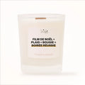 Bougie parfumée Les Fées Mères avec l'étiquette « Film de Noël + plaid + bougie = soirée réussie », pot blanc et mèche en bois de hêtre