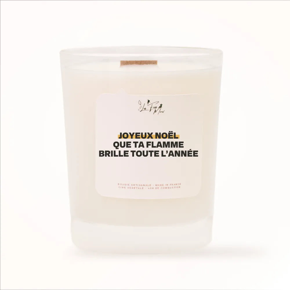 Bougie parfumée Les Fées Mères avec l'étiquette « Joyeux Noël que ta flamme brille toute l'année », pot blanc et mèche en bois de hêtre