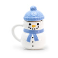 Bougie mug bonhomme de neige en céramique blanche, bonnet bleu à pompon en guise de couvercle et écharpe bleue, Les Fées Mères
