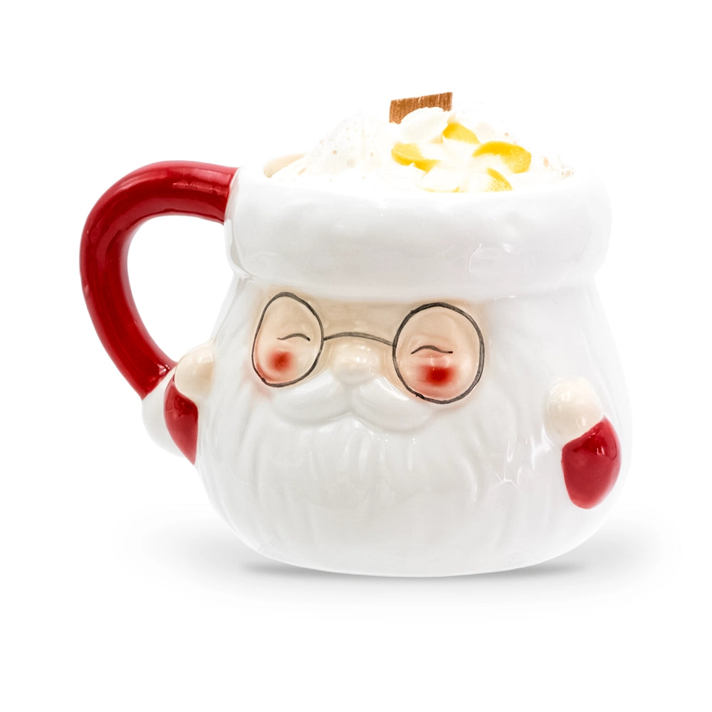 Bougie mug Père Noël clémentine monoï en céramique blanche à lunettes rondes, anse et moufles rouges, décor de cire blanche orné de fleurs jaunes et mèche en bois, Les Fées Mères