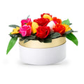 Composition en fleurs de savon multicolore Les Fées Mères, roses rouges, fuchsia et orange, tulipes jaunes et blanches et tournesols dans une boîte ronde blanche au liseré cuivre
