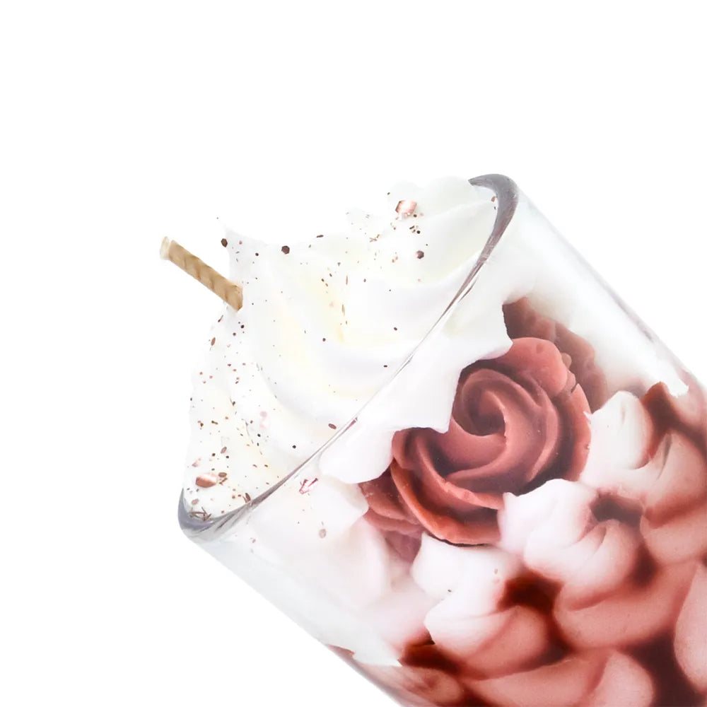 Petite bougie artisanale Les Fées Mères parfum bois de rose, en cire végétale française de tournesol et soja, décorée d’une chantilly façonnée à la main, cire rouge coulée à la main, aspect fleuri et décoratif, fleur façonné artisanalement, parfum de Grasse, bougie parfumée non comestible, fabrication artisanale française. Made in France, fabriquée dans les Vosges. Vue en zoom.