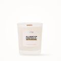 Petite bougie parfumée Les Fées Mères avec l'étiquette « All I want for Christmas is... cette bougie », petit format 20 heures, pot en verre blanc et mèche en bois de hêtre