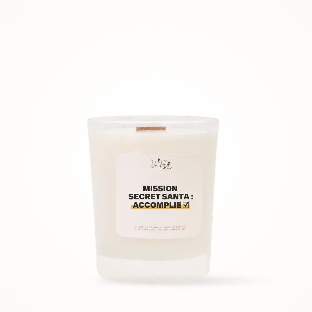 Petite bougie parfumée Les Fées Mères avec l'étiquette « Mission Secret Santa : accomplie », petit format 20 heures, pot en verre blanc et mèche en bois de hêtre