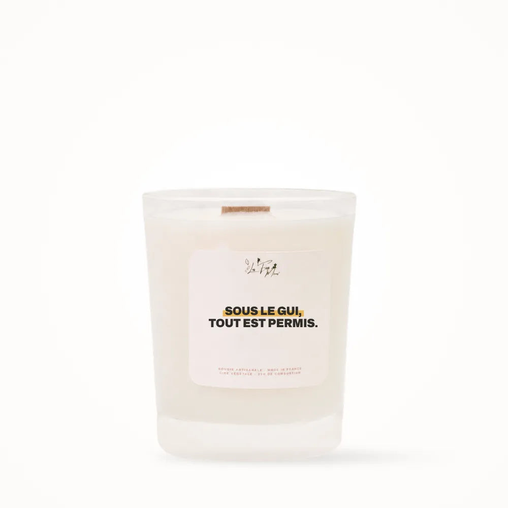 Petite bougie parfumée Les Fées Mères avec l'étiquette « Sous le gui, tout est permis », petit format 20 heures, pot en verre blanc et mèche en bois de hêtre