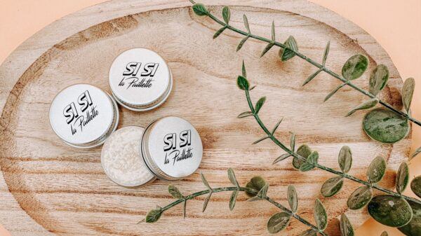 Baume applicateur de paillettes au beurre de karité avec son packaging blanc pour des lèvres hydratées toute la journée grâce aux bienfaits du beurre de karité