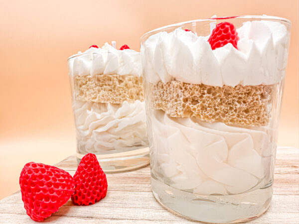 Vue de près du côté de notre bougie à la fraise. Vue de près de notre chantilly blanche ainsi que son crumble se situant au centre de la verrine.