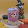 Bougie gourmande d'Halloween patchouli - musc - tonka - vanille, vue de face. Bougie multicolore avec un crâne inséré.