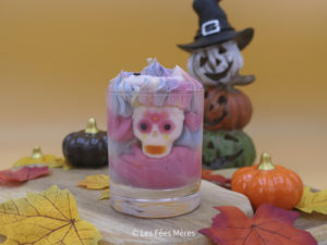 Bougie gourmande d'Halloween patchouli - musc - tonka - vanille, vue de face. Bougie multicolore avec un crâne inséré.