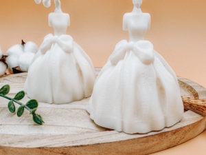Bougie décorative végétale robe de mariée princesse non parfumée. La mariée porte une robe princesse blanche avec un noeud à la taille.