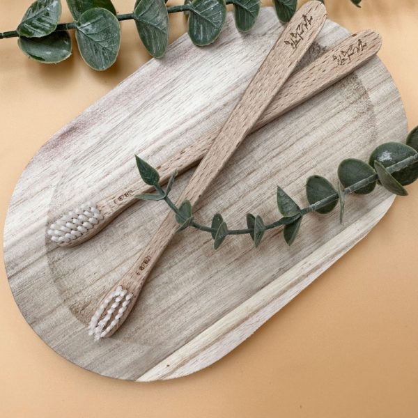 Brosse à dents écologique en bois de hêtre. Les brosses à dents sont présentées sur un plateau en bois.