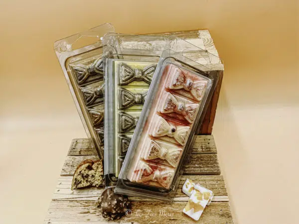 Barres fondantes en cire végétale parfumée. Ce sont des barres sécables de différentes couleurs en fonction de la senteur avec un motif de petits noeuds sur chaque carreau. fondant barre parfumé gourmand