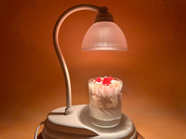 Lampe à bougie diffuseur d'ambiance et de parfum. Présenté avec bougie fraise des bois en dessous. Dans le noir allumé nous remarquons l'ambiance apportée