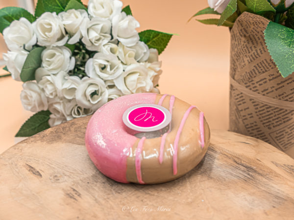 Ce produit est un savon gourmand en forme de donuts. Il est beige avec un nappage rose. C'est un savon donuts parfumé.