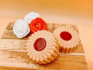 Cette photo représente le savon tartelette à la fraise. Ils sont par 2 disposé dans une jolie boîte et soigneusement emballé dans du papier de soie. Fabrication et savoir faire français.