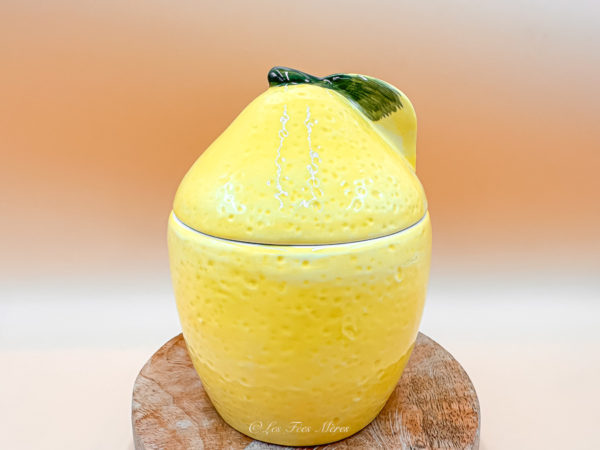 Un brûle parfum citron en céramique ! C'est allier l'originalité et le réalisme. Il est jaune et a des aspérités en surface faisant penser à une peau d'agrumes. Sous le couvercle on voit parfaitement une tranche de citron comme ci il était coupé. Photo fermé posé pour une décoration d'intérieur.