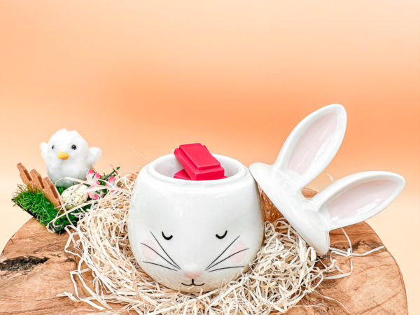 Un brûle parfum lapin en céramique ! Il est blanc avec des grandes oreilles blanche et rose pâle. Photo du lapin blanc de face en cours d'utilisation de fondant. Le couvercle, représenté par les oreilles est donc ouvert.