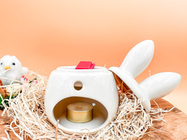 Un brûle parfum lapin en céramique ! Il est blanc avec des grandes oreilles blanche et rose pâle. Photo du lapin blanc de dos en cours d'utilisation de fondant. Le couvercle, représenté par les oreilles est donc ouvert.