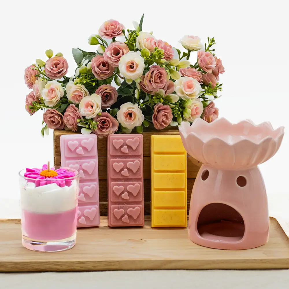 Cette photo représente un coffret qui contient une bougie gourmande parfumé - 30h de combustion, un brûle parfum au choix et 3 barres de fondants parfumés en cire végétale au choix. Ainsi qu'une bougie chauffe plat. Le tout fabriqué artisanalement en France. C'est un coffret bougie gourmande.
